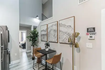 a dining room with a table and a refrigerator at Bi-Level 2BR Loft in Old City in Philadelphia