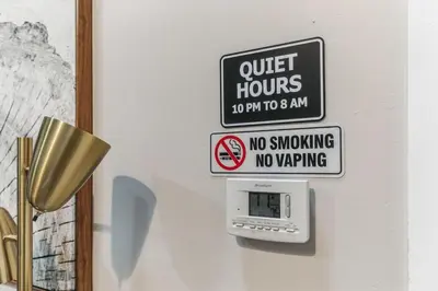 a sign that says quiet hours and no smoking no wrapping on a wall at Bi-Level 2BR Loft in Old City in Philadelphia