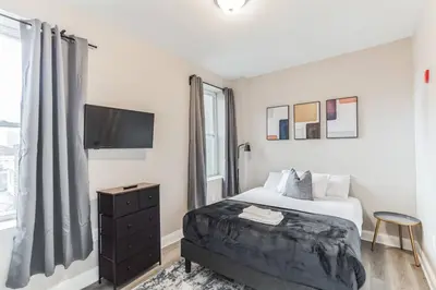 a hotel room with a bed and a tv at Bi-Level 2BR Loft in Old City in Philadelphia