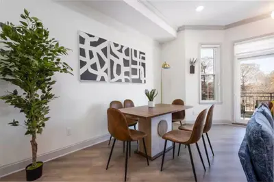 a dining room with a table and chairs and a potted tree at 2BR - Across from Fairmount Park -10 mins to DT in Philadelphia