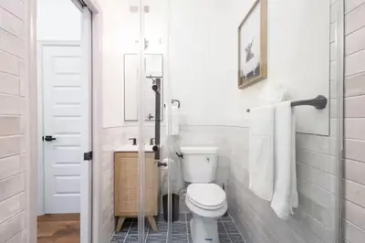 a white bathroom with a toilet and a sink at 2BR - Across from Fairmount Park -10 mins to DT in Philadelphia