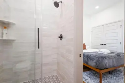 a white bathroom with a shower and a bed at 2BR - Across from Fairmount Park -10 mins to DT in Philadelphia