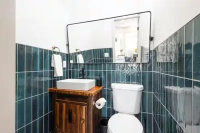 a bathroom with a toilet and a sink and a mirror at 2BR - Across from Fairmount Park -10 mins to DT in Philadelphia