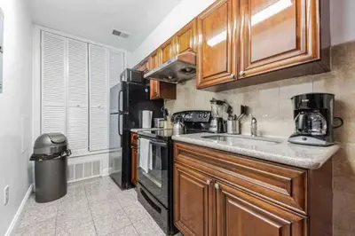 a kitchen with wooden cabinets and a sink at Cozy Studio across from Convention Center - 4R in Philadelphia