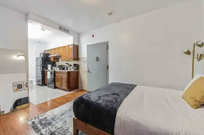 a bedroom with a large bed and a kitchen at Cozy Studio across from Convention Center - 4R in Philadelphia