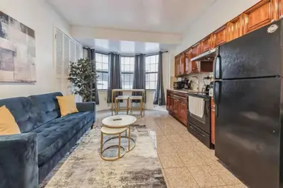 a living room with a blue couch and a kitchen at Across from Convention Center 4F - Sleeps 6 - 4F in Philadelphia