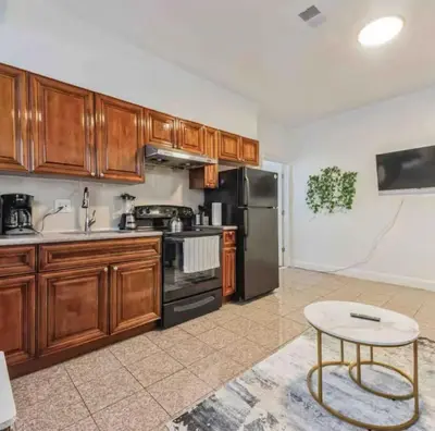 a kitchen with wooden cabinets and a black refrigerator at Across from Convention Center 4F - Sleeps 6 - 4F in Philadelphia