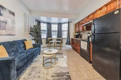 a living room with a blue couch and a kitchen at Across from Convention Center - Sleeps 6 - 3F in Philadelphia