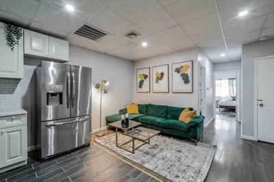 a living room with a green couch and a refrigerator at BRAND NEW Modern 2BR - Heart of Center City in Philadelphia