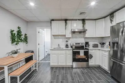 a kitchen with white cabinets and a stove top oven at BRAND NEW Modern 2BR - Heart of Center City in Philadelphia
