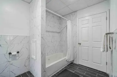 a white bathroom with a white door and a bath tub at BRAND NEW Modern 2BR - Heart of Center City in Philadelphia