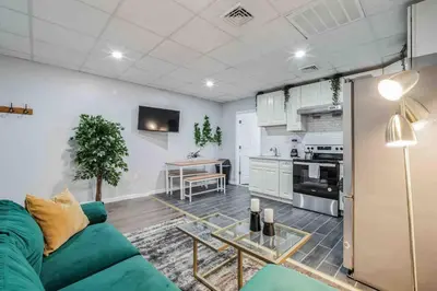 a living room with a green couch and a table at BRAND NEW Modern 2BR - Heart of Center City in Philadelphia