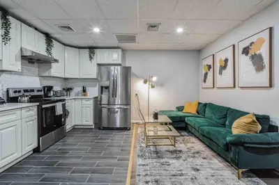a living room with a green couch in a kitchen at BRAND NEW Modern 2BR - Heart of Center City in Philadelphia