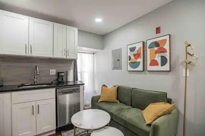 a living room with a green couch and a kitchen at Cozy 1BR - Center City - Sleeps 4 - 2 Beds in Philadelphia