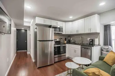 a kitchen with white cabinets and a stainless steel refrigerator at Cozy 1BR - Center City - Sleeps 4 - 2 Beds in Philadelphia