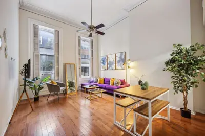 a living room with a purple couch and a table at Large and Sunny 1BR Located Near Rittenhouse Square in Philadelphia