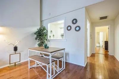 a living room with a table and a mirror at Large and Sunny 1BR Located Near Rittenhouse Square in Philadelphia