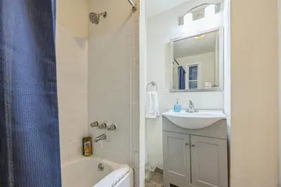 a bathroom with a sink and a tub and a mirror at Large and Sunny 1BR Located Near Rittenhouse Square in Philadelphia