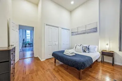 a white bedroom with a bed and a table at Large and Sunny 1BR Located Near Rittenhouse Square in Philadelphia