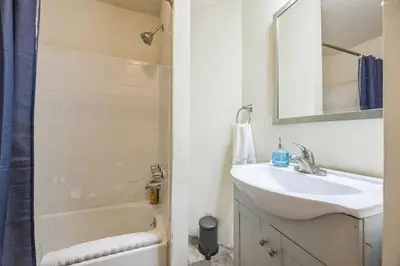 a white bathroom with a sink and a mirror at Large and Sunny 1BR Located Near Rittenhouse Square in Philadelphia