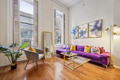 a living room with a purple couch and a table at Large and Sunny 1BR Located Near Rittenhouse Square in Philadelphia