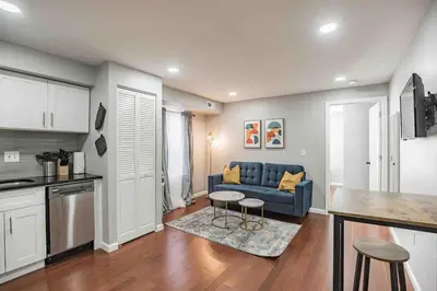 a living room with a blue couch and a kitchen at Modern and Stylish Center City 1BR - Perfect Location in Philadelphia