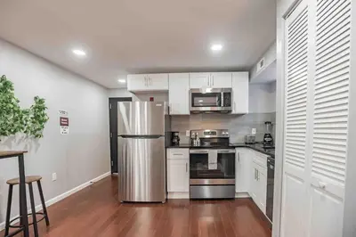 a kitchen with white cabinets and a stainless steel refrigerator at Modern and Stylish Center City 1BR - Perfect Location in Philadelphia