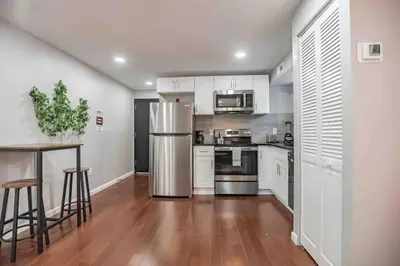 a kitchen with white cabinets and a stainless steel refrigerator at Modern and Stylish Center City 1BR - Perfect Location in Philadelphia