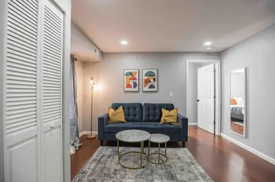 a living room with a blue couch and a table at Modern and Stylish Center City 1BR - Perfect Location in Philadelphia