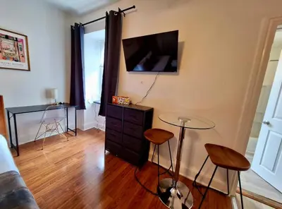 a living room with a tv and a table and stools at Prime Location Studio in Center City with Fast Wifi in Philadelphia