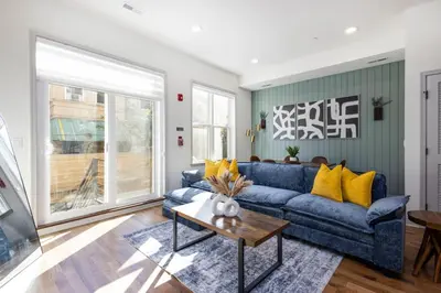 a living room with a blue couch and yellow pillows at 2BR - Fairmount Park -10 mins to DT - Sleeps 10 in Philadelphia