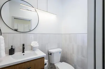 a bathroom with a white toilet and a mirror at 2BR - Fairmount Park -10 mins to DT - Sleeps 10 in Philadelphia
