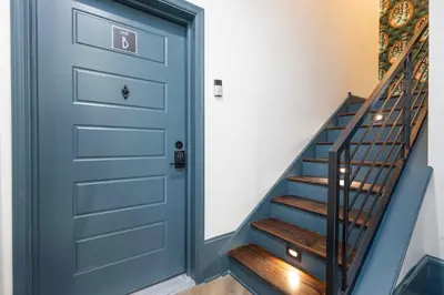 a blue door in a hallway with stairs at 2BR - Fairmount Park -10 mins to DT - Sleeps 10 in Philadelphia