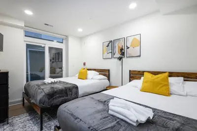 two beds in a bedroom with yellow pillows at 2BR - Fairmount Park -10 mins to DT - Sleeps 10 in Philadelphia