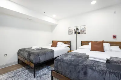 two beds in a room with white walls at 2BR w Balcony - Fairmount Park - 10 mins to DT in Philadelphia