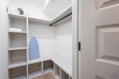 a walk in closet with white shelves and a door at 2BR w Balcony - Fairmount Park - 10 mins to DT in Philadelphia