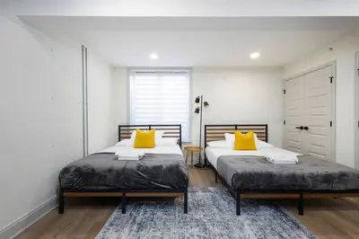 two beds in a room with white walls and yellow pillows at 2BR w Balcony - Fairmount Park - 10 mins to DT in Philadelphia