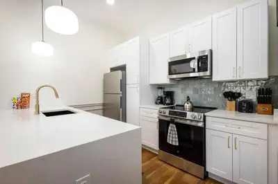 a kitchen with white cabinets and a black stove top oven at 2BR w Balcony - Fairmount Park - 10 mins to DT in Philadelphia