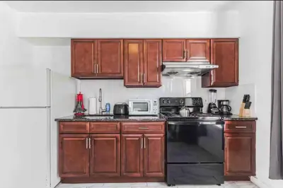 a kitchen with wooden cabinets and a black dishwasher at Spring Garden Small and Cozy Studio Sleeps 4 in Philadelphia