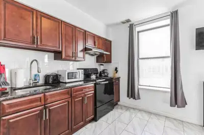 a kitchen with wooden cabinets and a window at Spring Garden Small and Cozy Studio Sleeps 4 in Philadelphia
