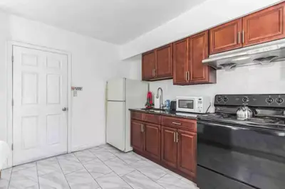 a kitchen with wooden cabinets and a black refrigerator at Spring Garden Small and Cozy Studio Sleeps 4 in Philadelphia