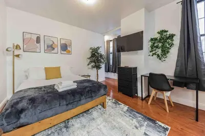 a bedroom with a bed and a desk and a chair at Cozy Studio Across from Convention Center - 3R in Philadelphia