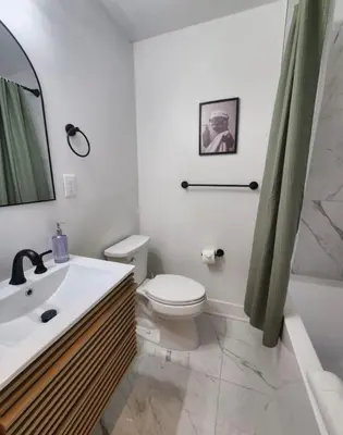a white bathroom with a toilet and a sink at Renovated Jr 1BR - Center City - Sleeps 4 - 2 Beds in Philadelphia