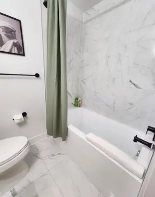 a white bathroom with a tub and a toilet at Renovated Jr 1BR - Center City - Sleeps 4 - 2 Beds in Philadelphia