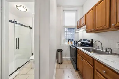 a small kitchen with a sink and a shower at Charming Studio in the Heart of Center City with Fast WiFi in Philadelphia