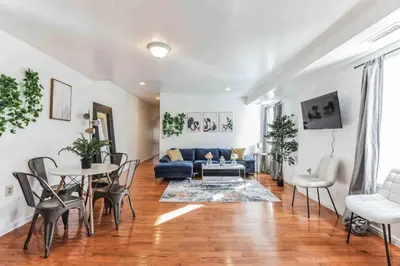 a living room with a blue couch and a table and chairs at Large 3BR in Spring Garden in Philadelphia