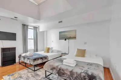 a white room with two beds and a tv at Large 3BR in Spring Garden in Philadelphia