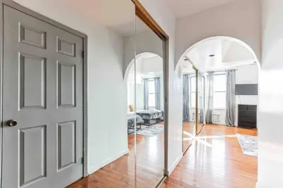 a hallway with an open door and a mirror at Large 3BR in Spring Garden in Philadelphia