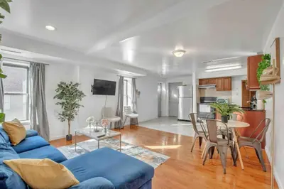 a living room with a blue couch and a table at Large 3BR in Spring Garden in Philadelphia