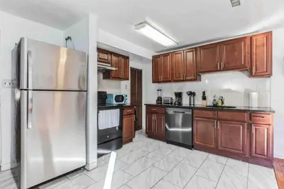 a kitchen with wooden cabinets and a stainless steel refrigerator at Large 3BR in Spring Garden in Philadelphia